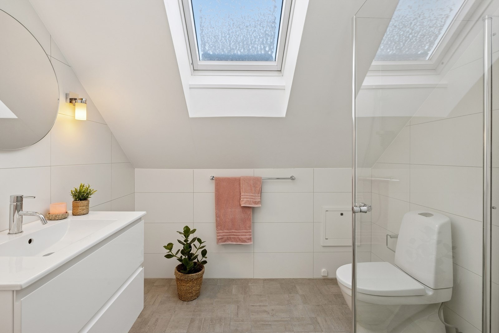 Badet inneholder nedfelt servant, toalett og dusjhjørne med dusjvegger. Galleribilde