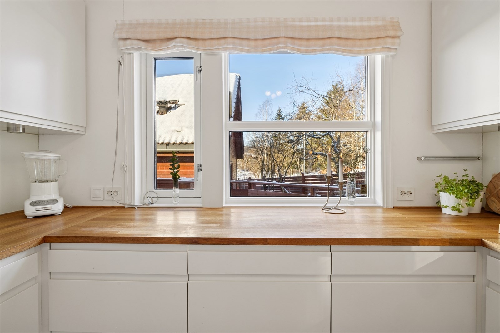 Takhøye skap gir rikelig lagringsplass og utnytter romhøyden godt, mens de store vinduene slipper inn rikelig med dagslys og gir et flott utsyn over nærområdet. Galleribilde