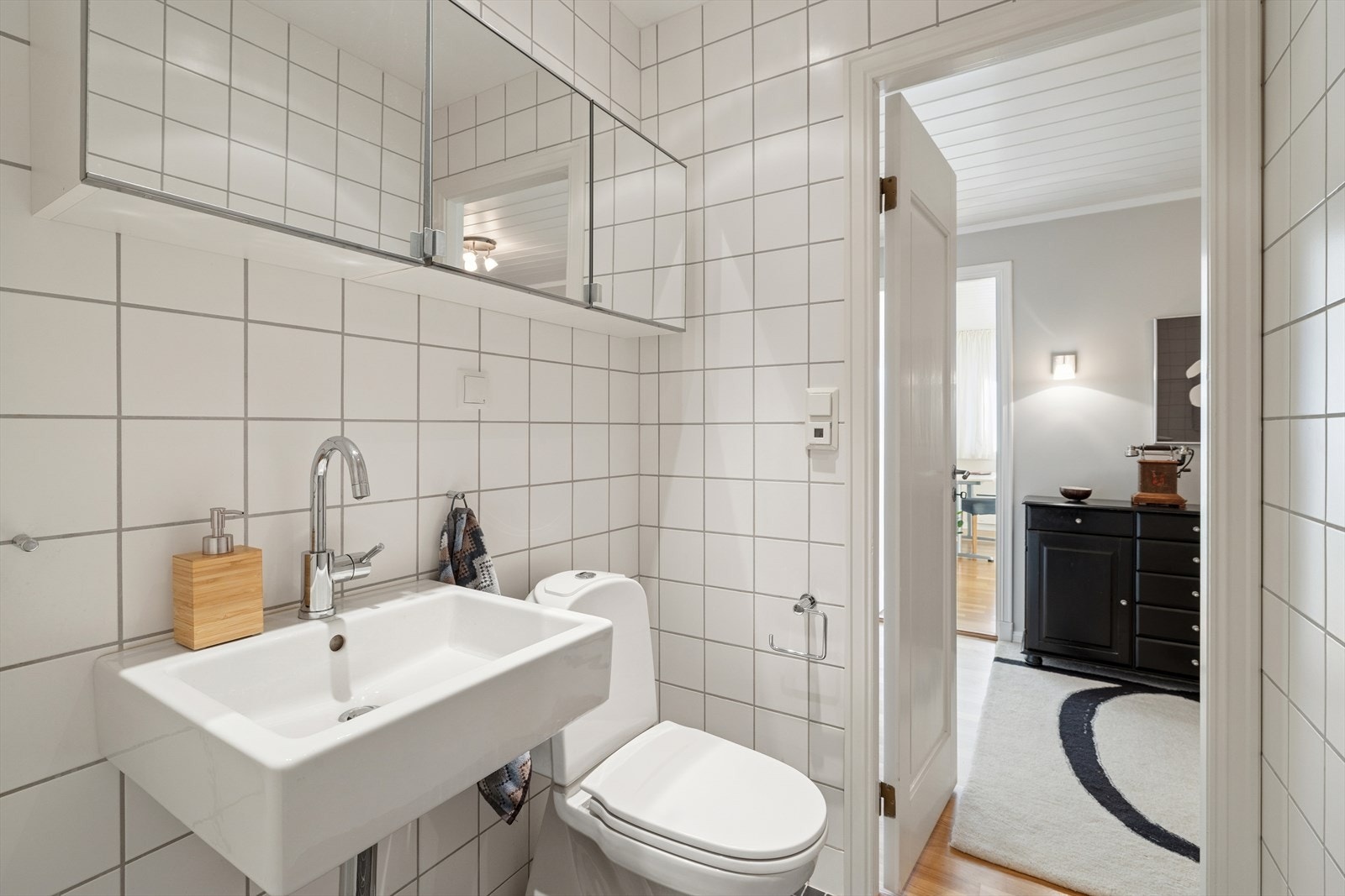 Videre i denne etasjen finner man tilkomst til både et praktisk vaskerom og et pent baderom, begge oppgradert i 2007 og plassert i boligens underetasje. Rommene er gjennomført i samme stil, noe som gir en helhetlig og moderne følelse. Galleribilde