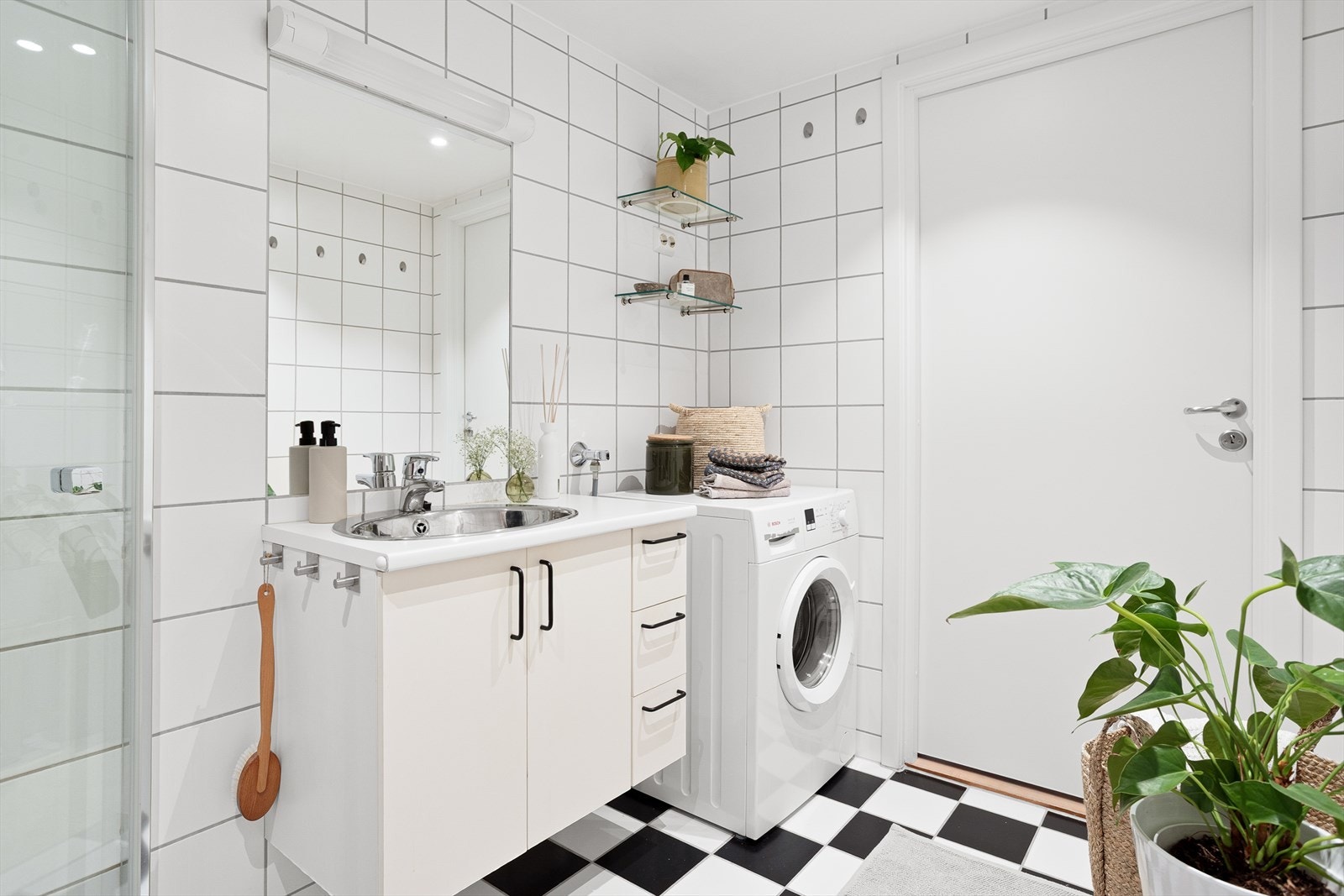 Badet er innredet med klosett, servant nedfelt i innredning og dusjhjørne med svingbare glassdører. Galleribilde