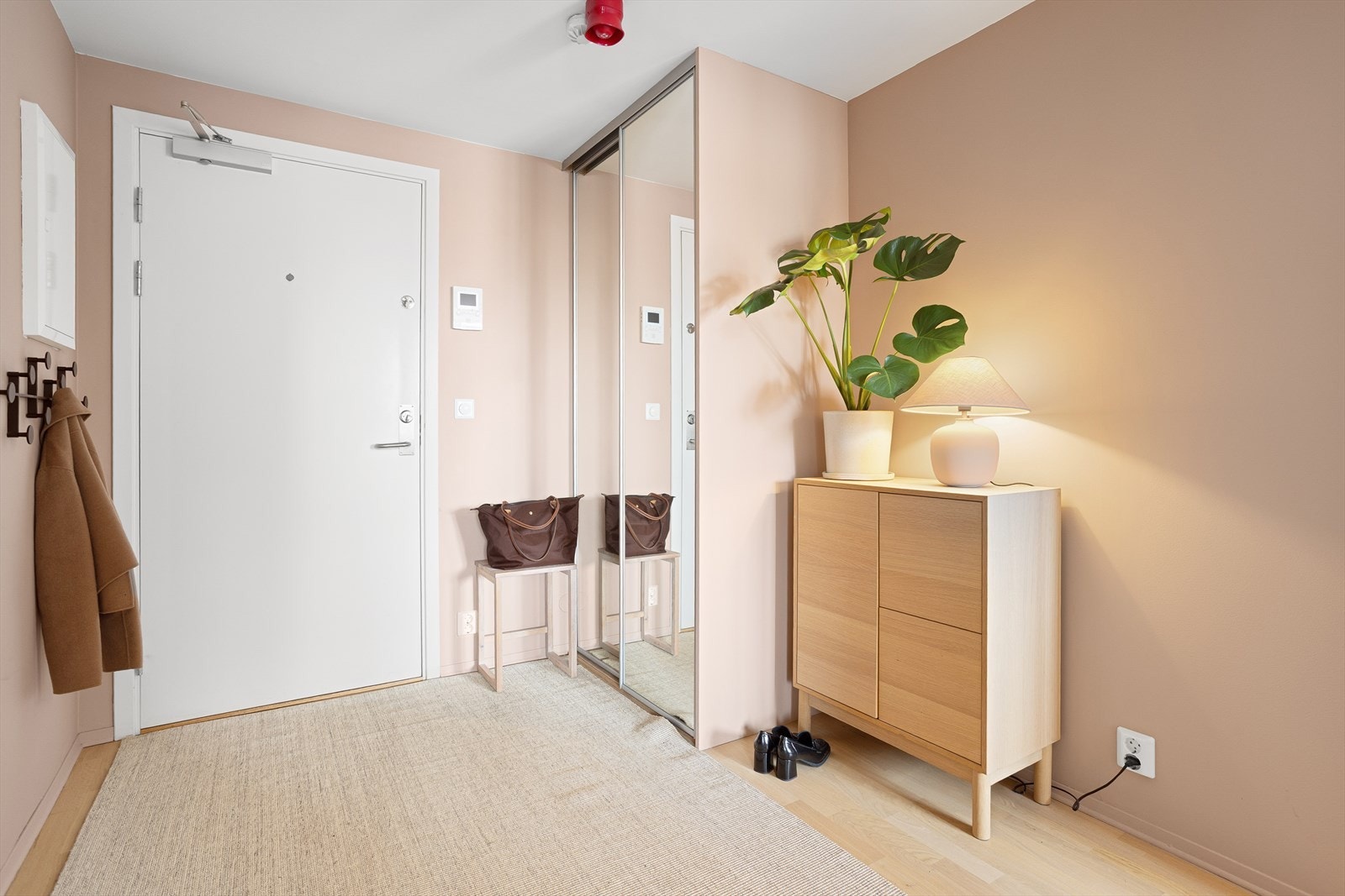 Romslig og innbydende entré med plassbygd skyvedørsgarderobe. Galleribilde