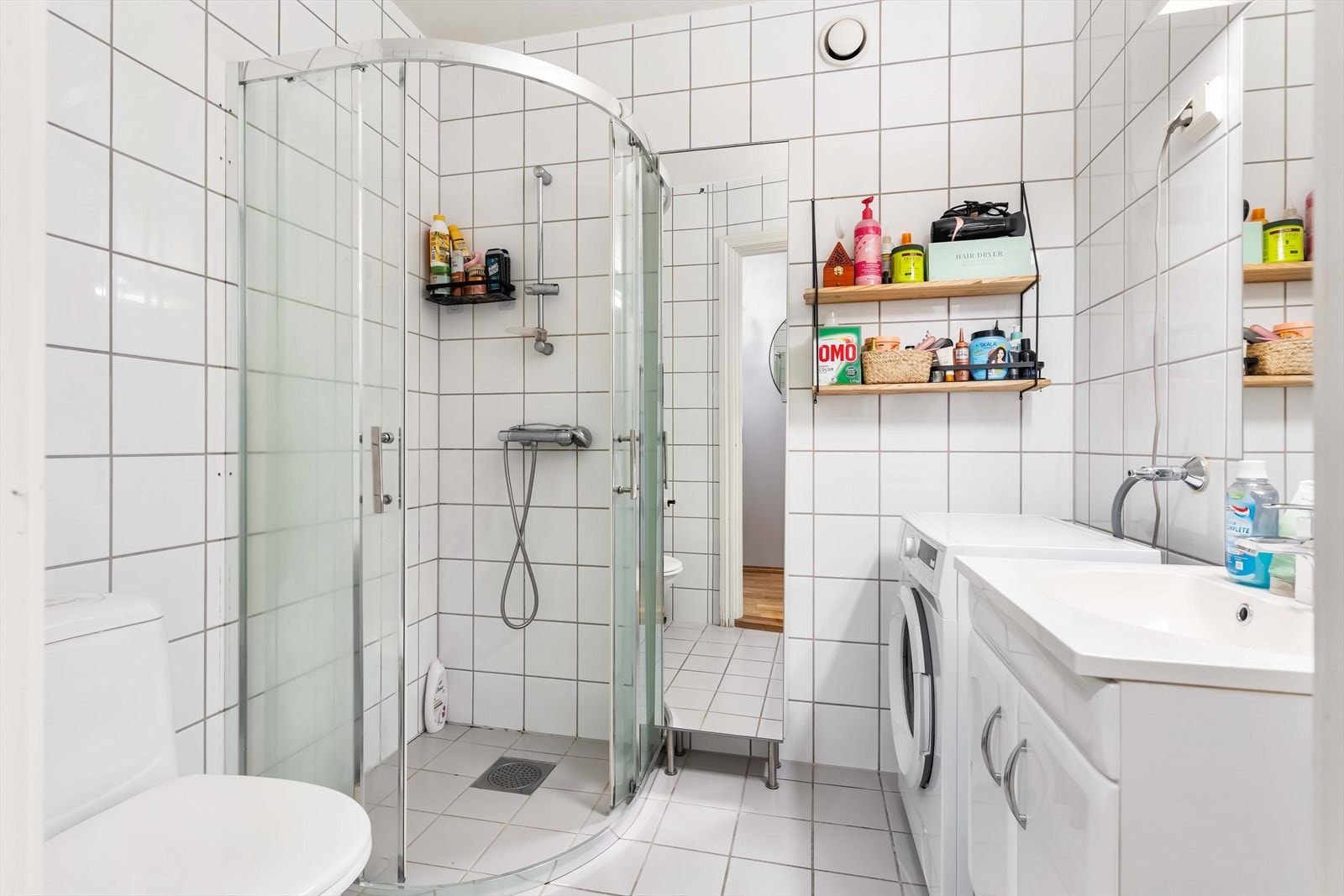 Flislagte overflater og elektriske varmekabler gir en robust våtromsløsning. Dusjhjørne med svingdører og mekanisk avtrekk sikrer praktisk bruk. Galleribilde