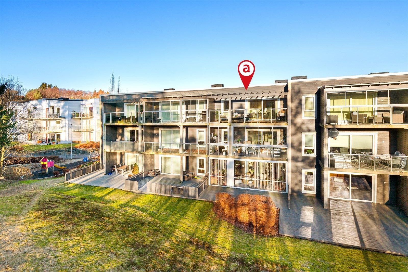 Balkongen vender sør mot grønne fellesarealer - gode solforhold. Galleribilde