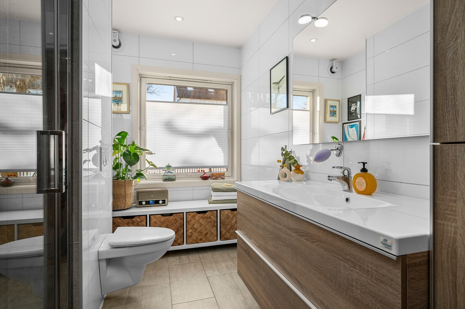 Flislagt bad i hovedetasje. Rommet har servantskap, opplegg for vaskemaskin, dusj og vegghengt wc. Galleribilde