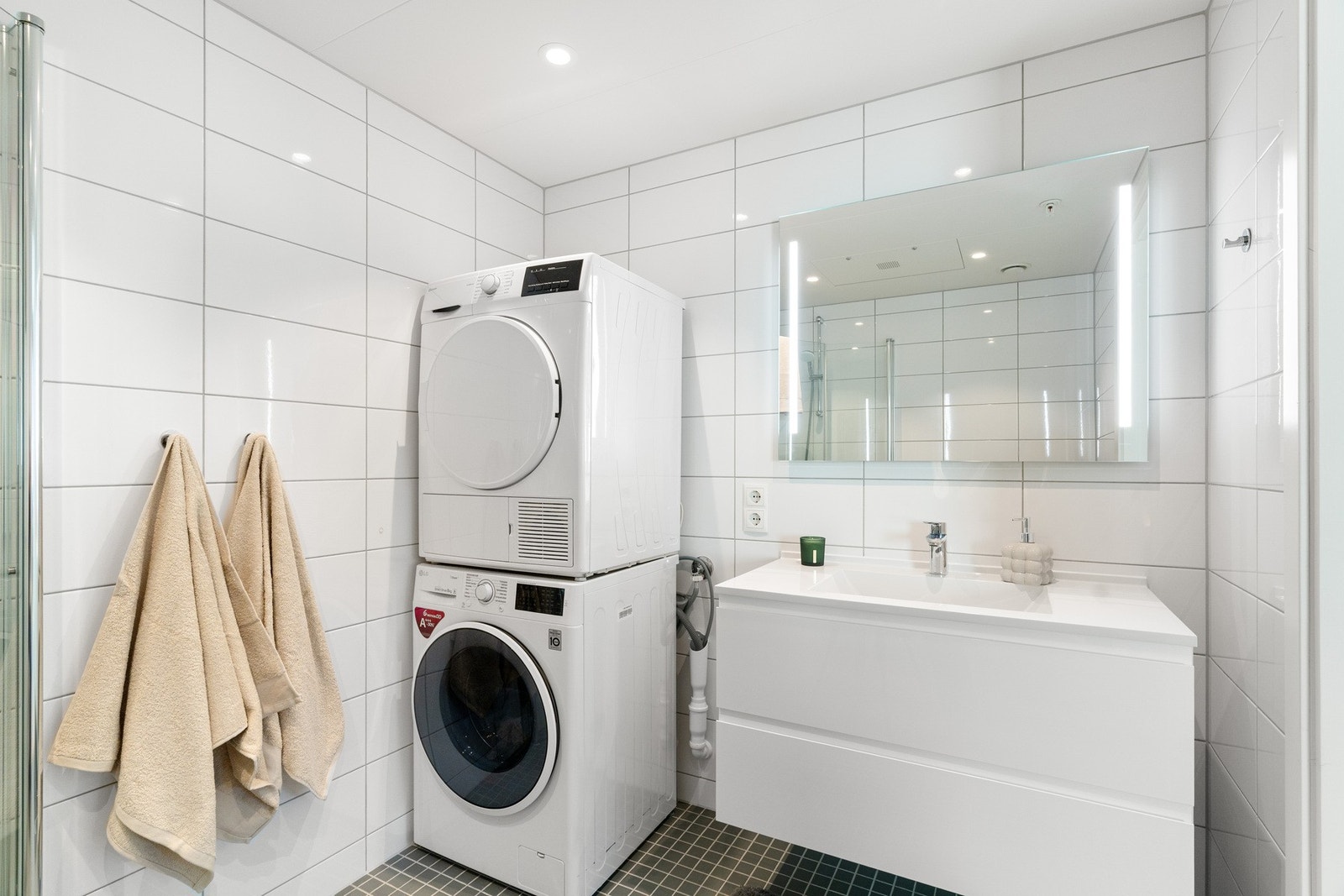 Utstyrt med dusjhjørne med innfellbare vegger, vegghengt WC, servant og servantskap, speil med belysning på speiloverflate, spotter i himling, opplegg for vaskemaskin, og varmekabler i gulv. Galleribilde