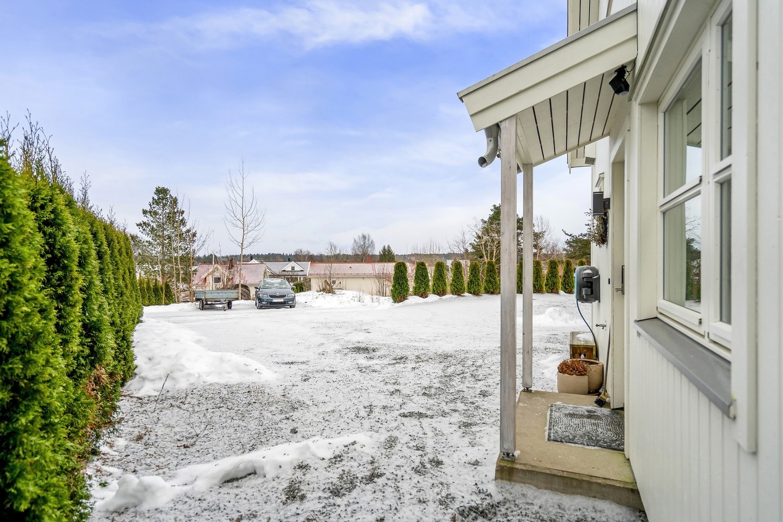 Stor og gruset gårdsplass med biloppstillingsplasser. Galleribilde