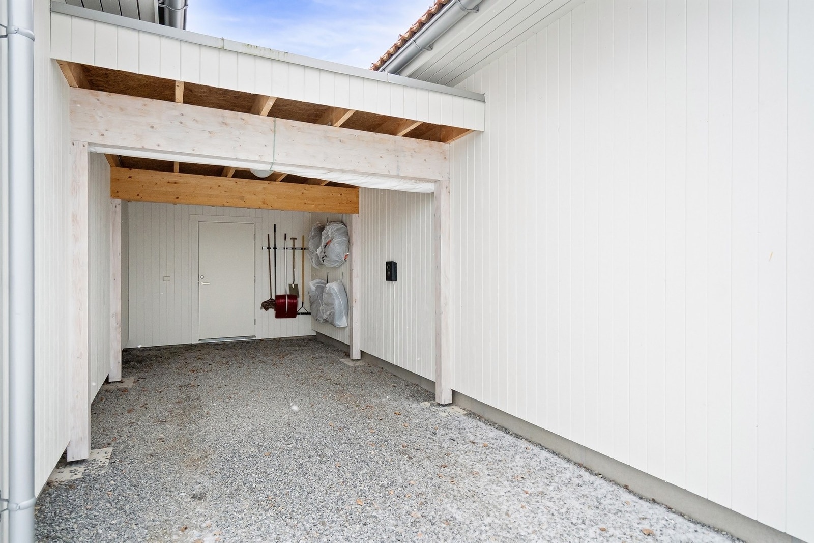 Praktisk parkering i carport med lader. Det er bod i enden. Galleribilde