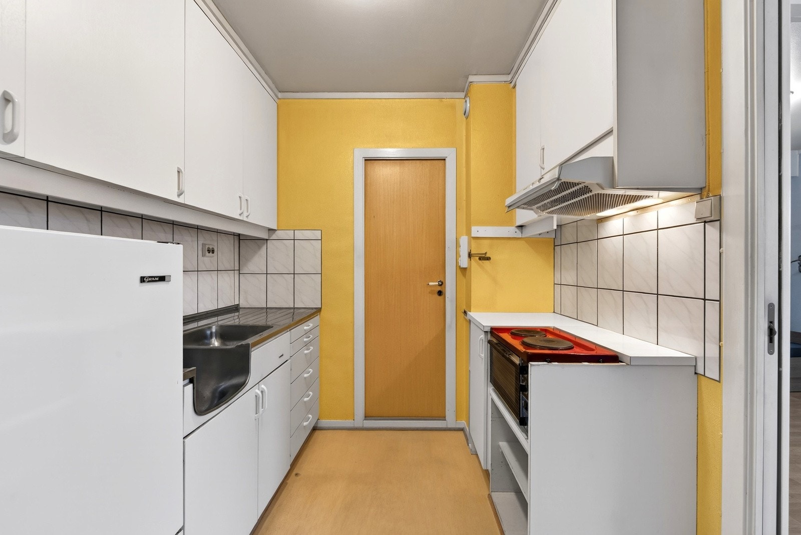 Kjøkken med dør inn til baderom. Galleribilde