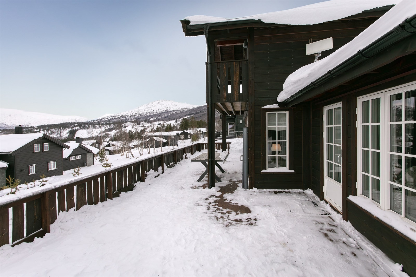 Stor terrasse i front av hytten med god plass til flere soner og sitteplasser Galleribilde
