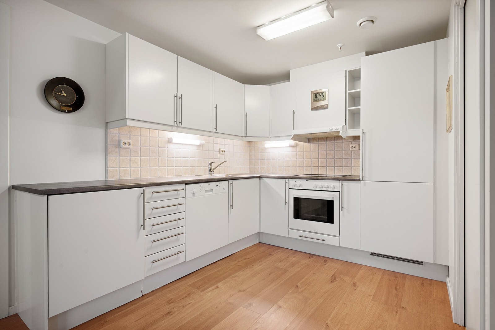 Kjøkkeninnredningen er fra Norema med hvitmalte slette fronter og laminerte benkeplater Galleribilde