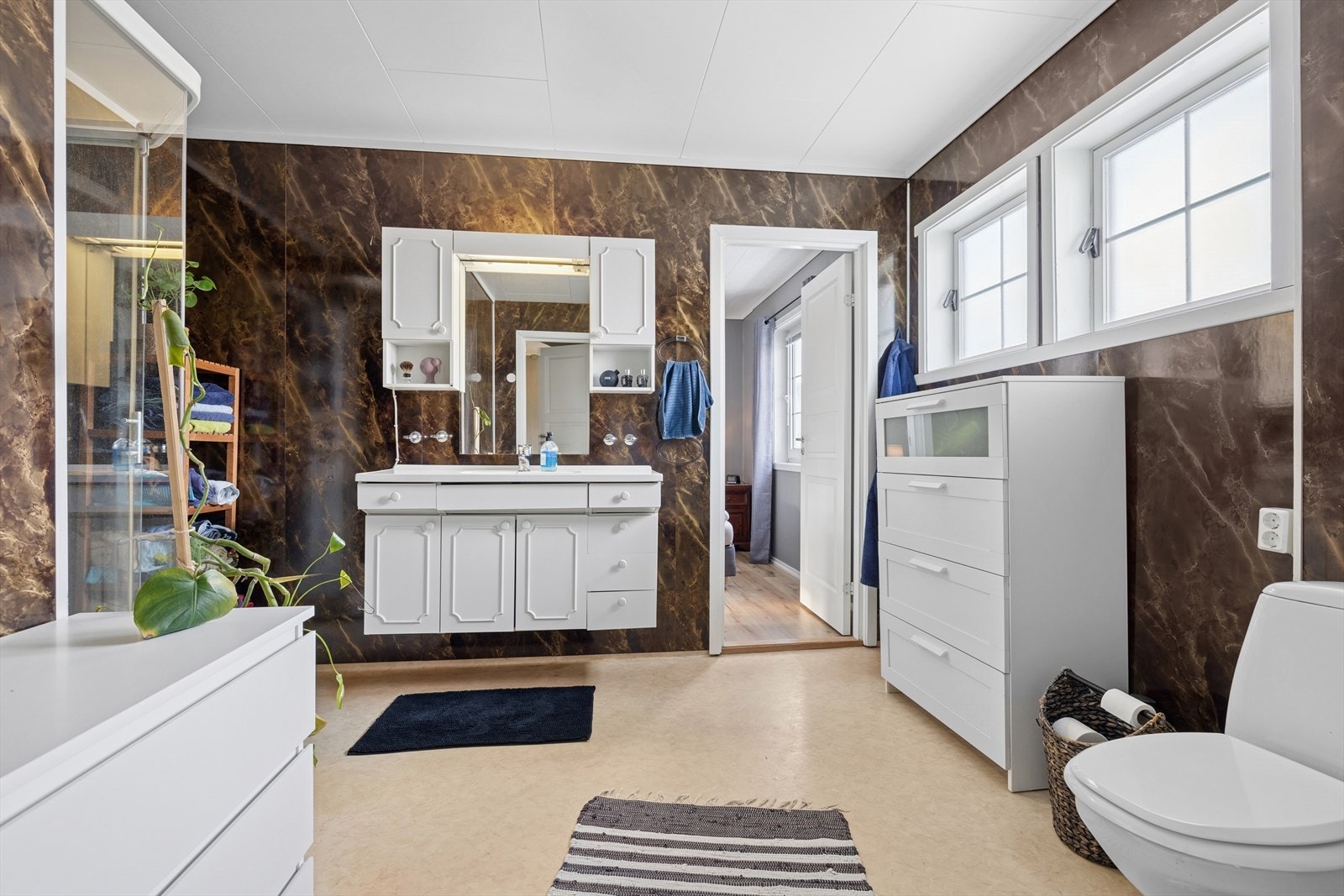 Badet har baderomsplater på veggene og vinylbelegg med elektriske varmekabler på gulvet. Galleribilde