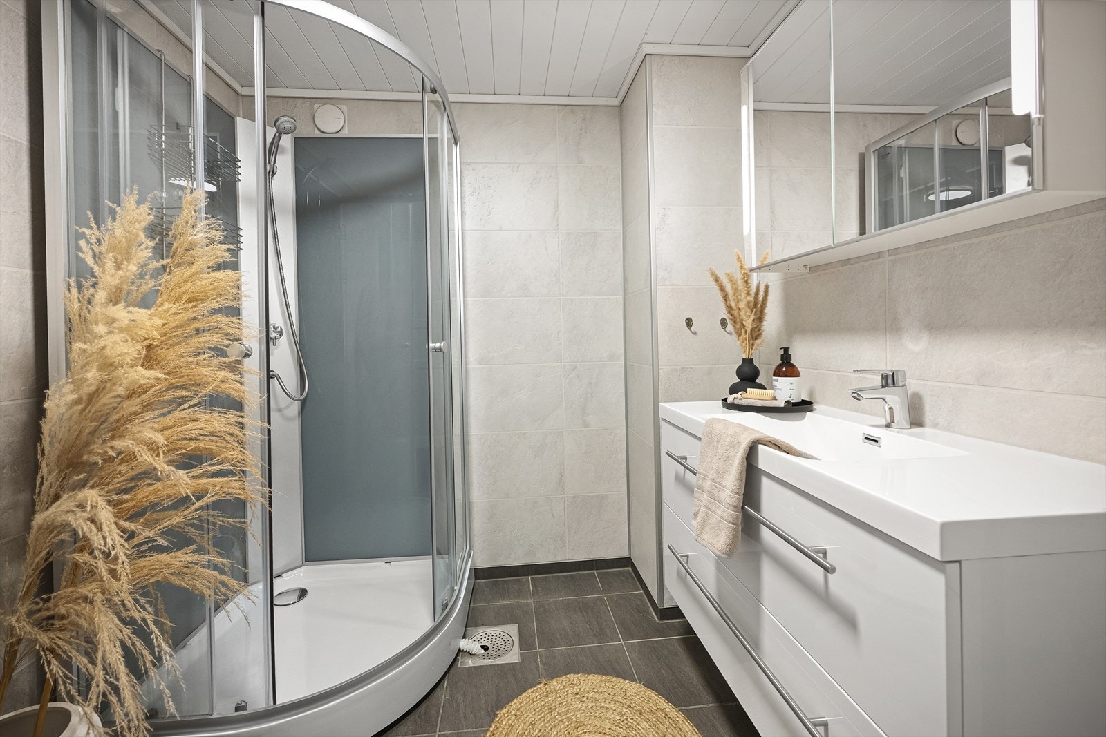 Lyst og moderne bad med elegant dusjhjørne og stilren innredning. Perfekt for en avslappende start på dagen. Galleribilde