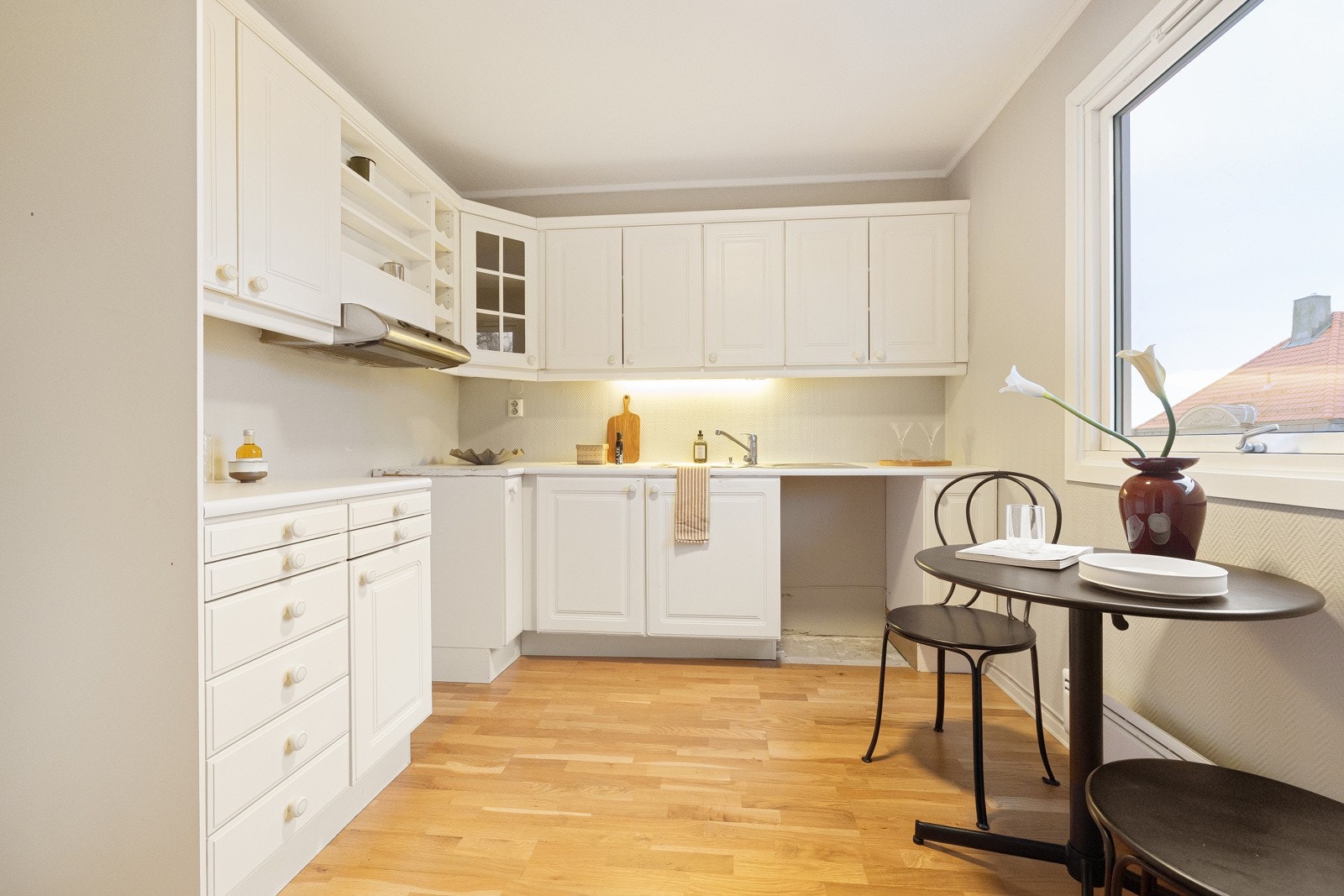 Kjøkkeninnredningen har hvite, profilerte fronter. Innredningen byr på rikelig med over- og underskap som gir gode oppbevaringsmuligheter Galleribilde