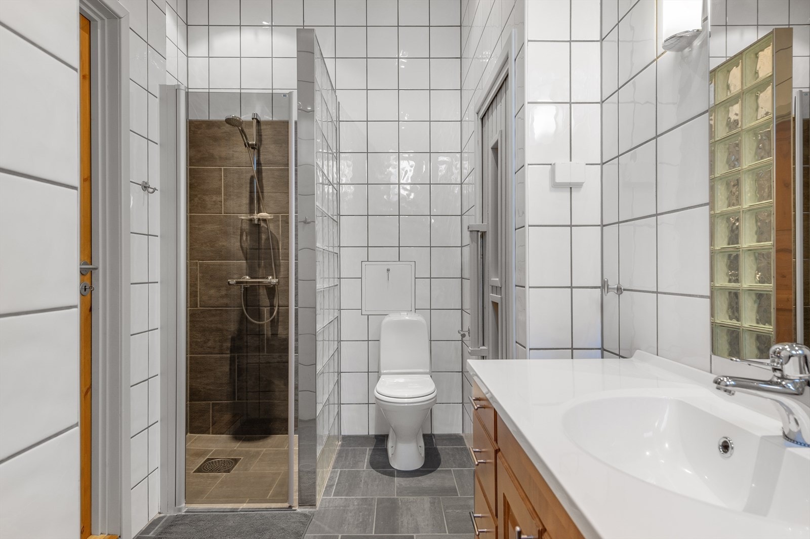 Baderommet er i dag utstyrt med gulvstående toalett og dusjnisje, og fremstår som funksjonelt og praktisk. Galleribilde