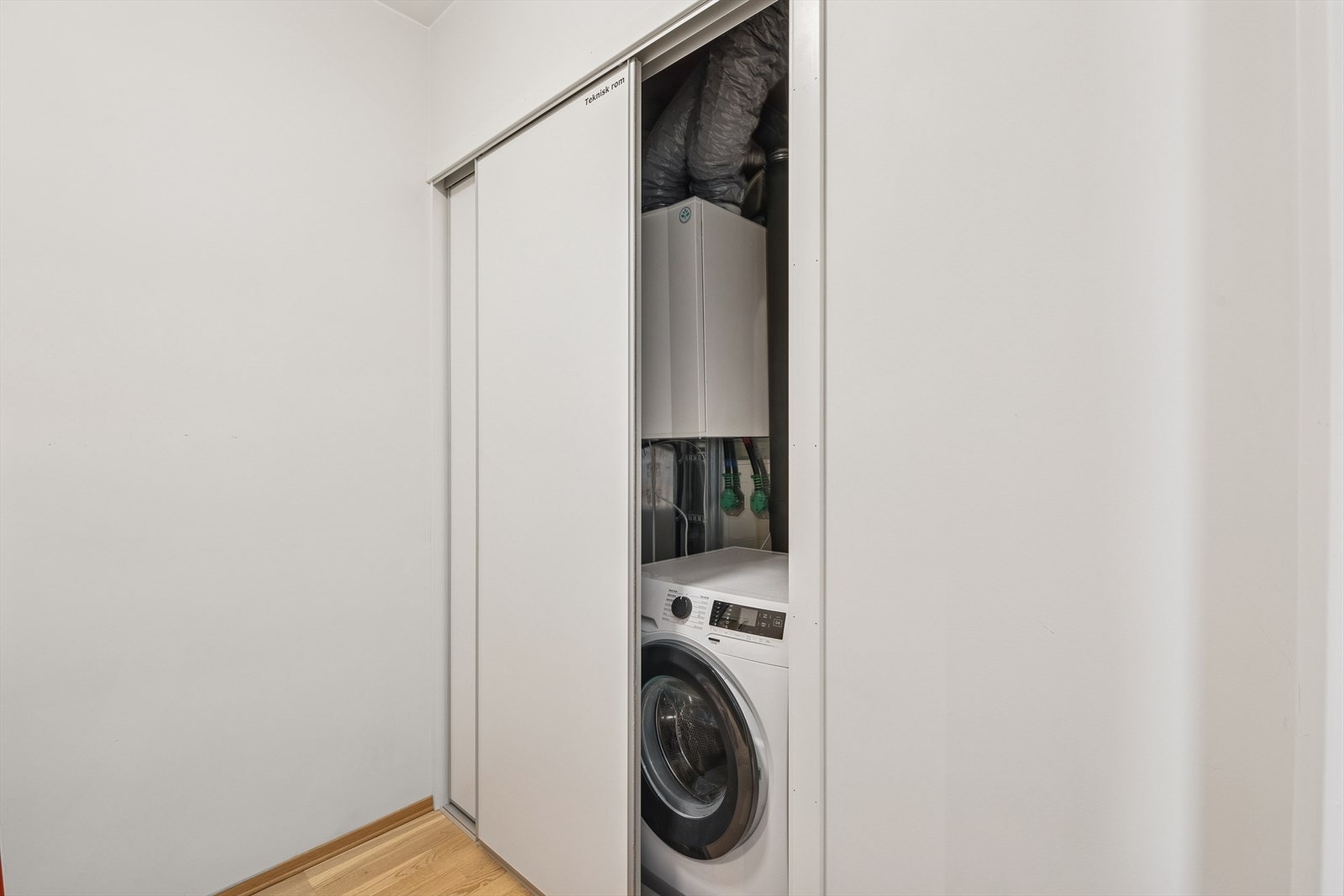 Vaskemaskinene har en fin plassering bak skyvedører. Galleribilde