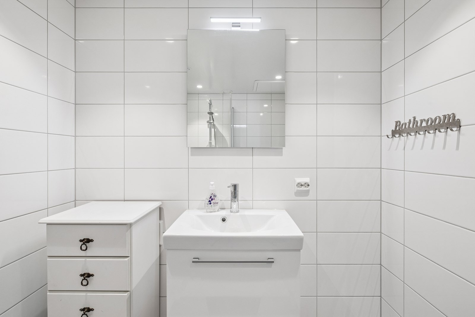 Rommet er utstyrt med en heldekkende servant med ettgreps blandebatteri, veggmontert toalett og dusjvegger med dusjsett. Galleribilde