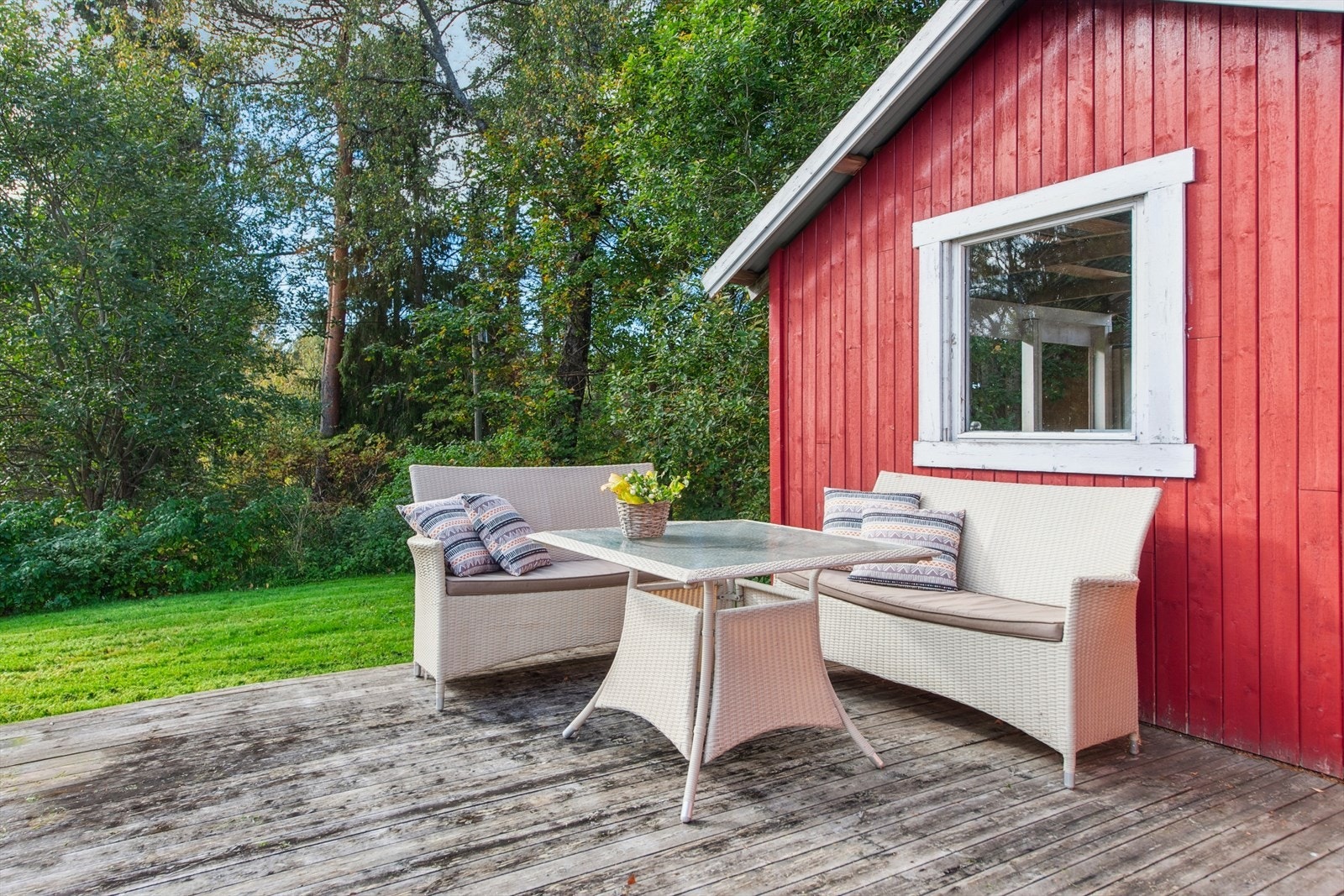 Koselig uteplass med rød, sjarmerende utestue. Omgitt av frodig natur og grøntområde mot elven på nedsiden av boligen. Galleribilde