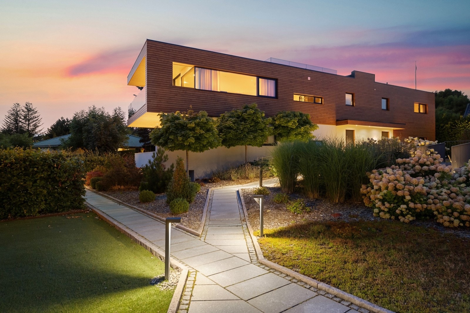 Parkmessig opparbeidet tomt tilhørende sameiet, med hellelagte gangveier, belysning, og vakker beplantning Galleribilde