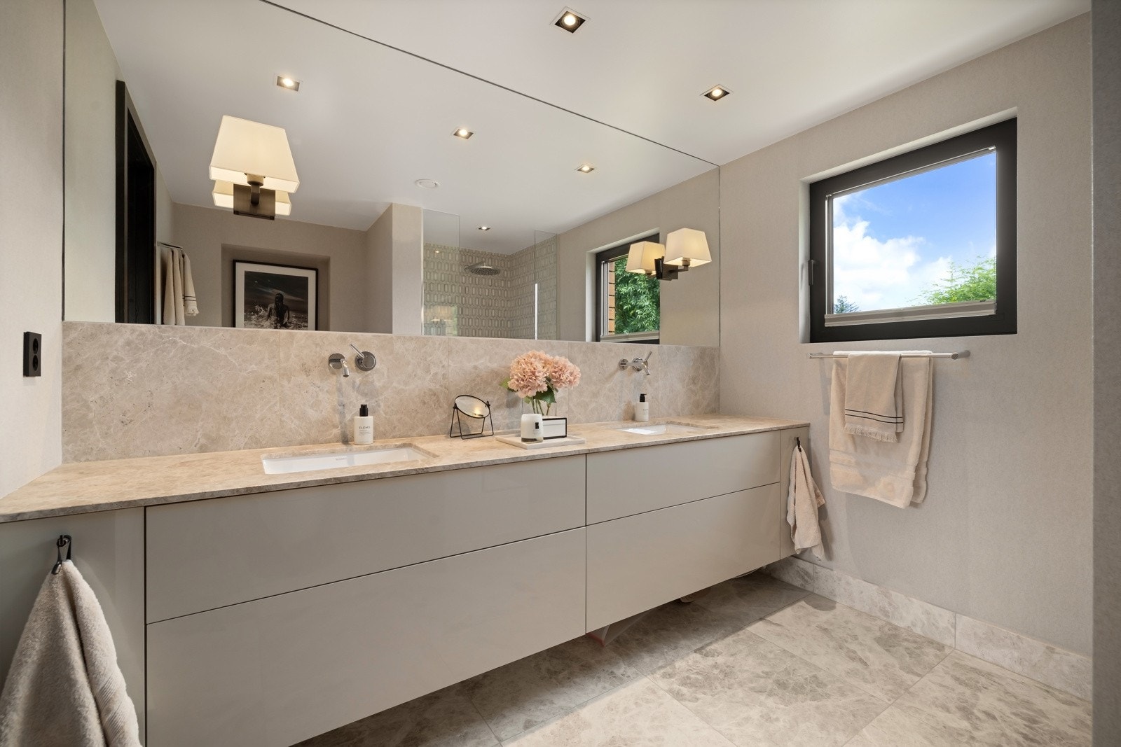 Hovedbad fremstår som stilrent, med flislagte vegger og gulv, samt slett himling. Utstyrt med dusjhjørne med glassvegger, innredning med steinplate og doble servanter, vegghengt toalett og moderne armaturer. Galleribilde