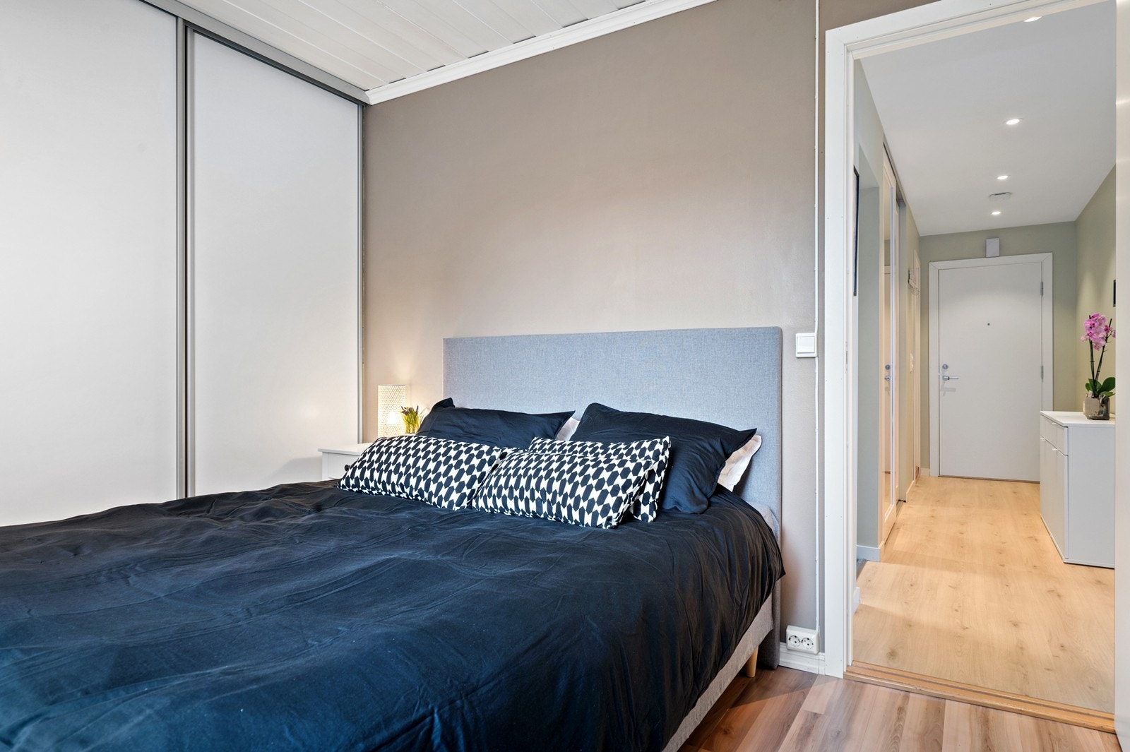 Rommet har dust fargevalg, som passer godt på soverommet. Det er plass til både seng og arbeidsplass. Galleribilde