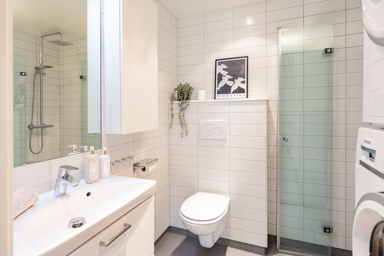 Leilighetens andre bad har opplegg for vaskemaskin og plass til tørketrommel. Her er det satt inn dusj gjennom tilvalg. Galleribilde