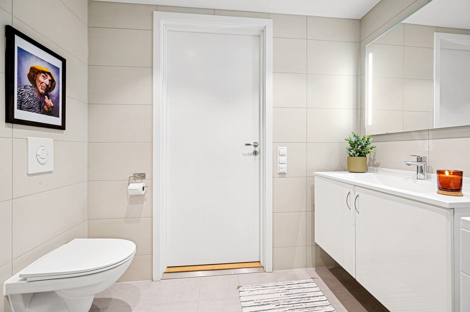 Badet er innredet med spotter i himling, servant med underskap og speil med innfelte lys, i tillegg til ekstra skapplass for praktisk oppbevaring. Galleribilde