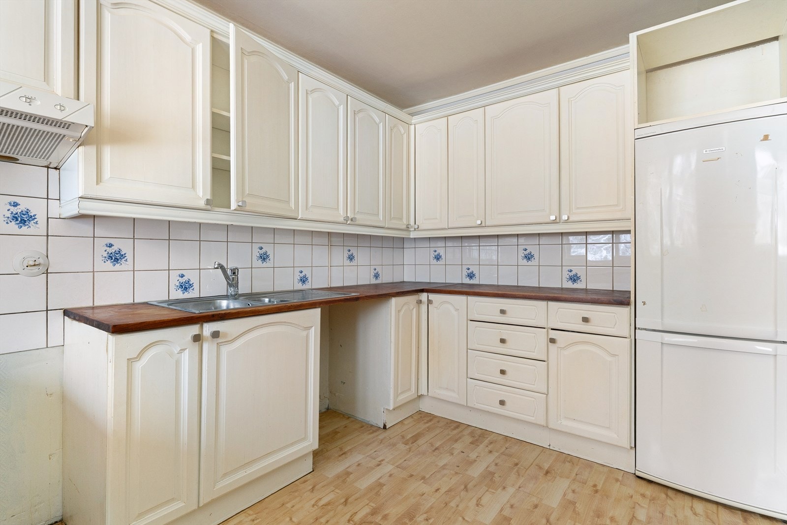 Kjøkkeninnredningen har profilerte fronter, heltre benkeplate, vaskekum, ventilator og kjøl/frys. Galleribilde