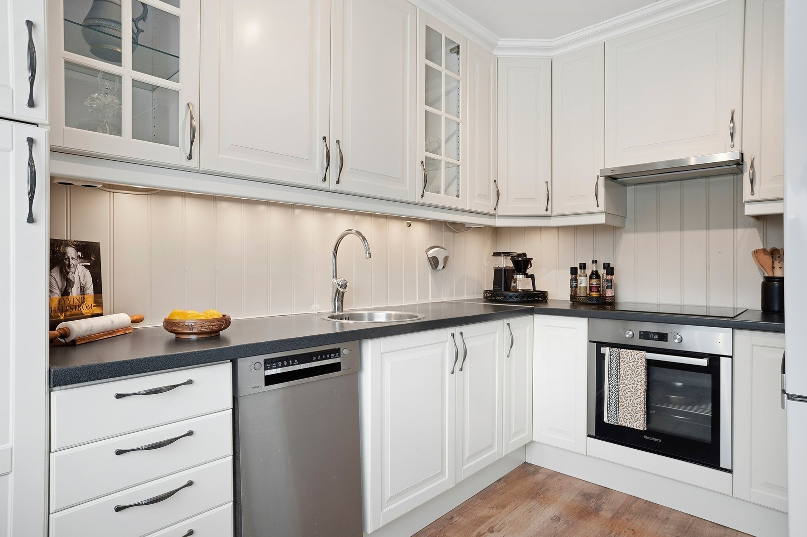 Klassisk kjøkkeninnredning med profilerte fronter, vitrineskap og rikelig med benke- og lagringsplass. Galleribilde