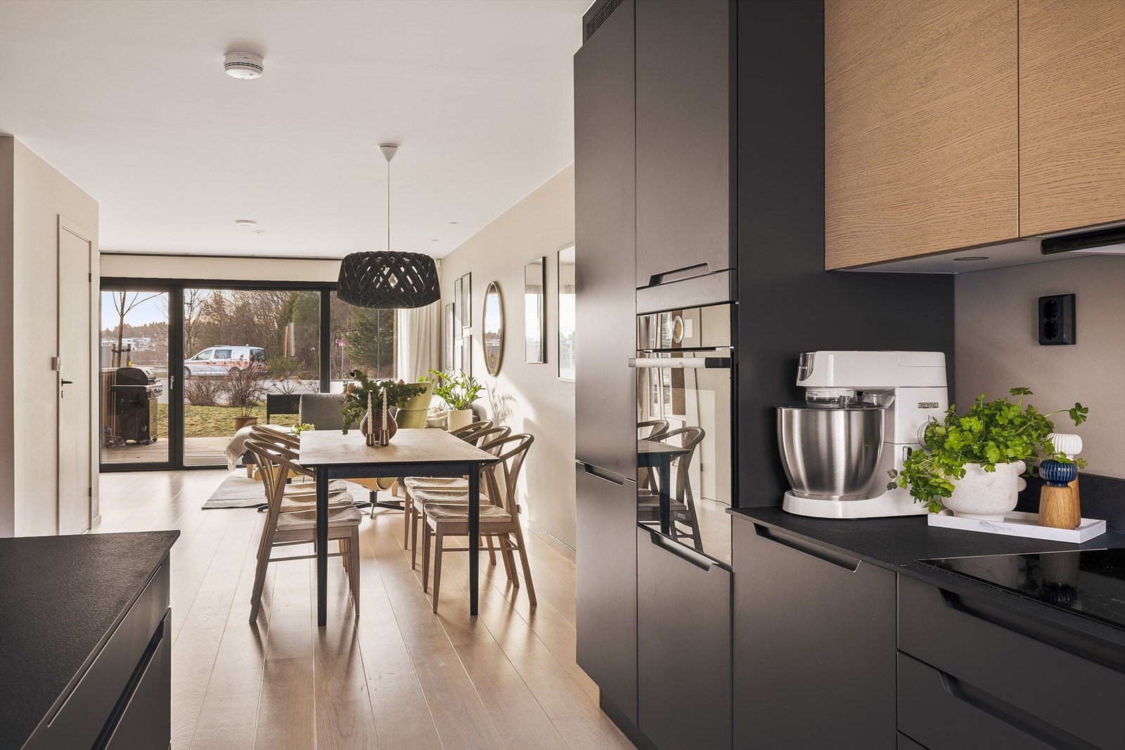 Leiligheten har naturlige overganger mellom sonene, der kjøkken, spiseplass og stue flyter sømløst sammen og skaper en harmonisk helhet. Galleribilde