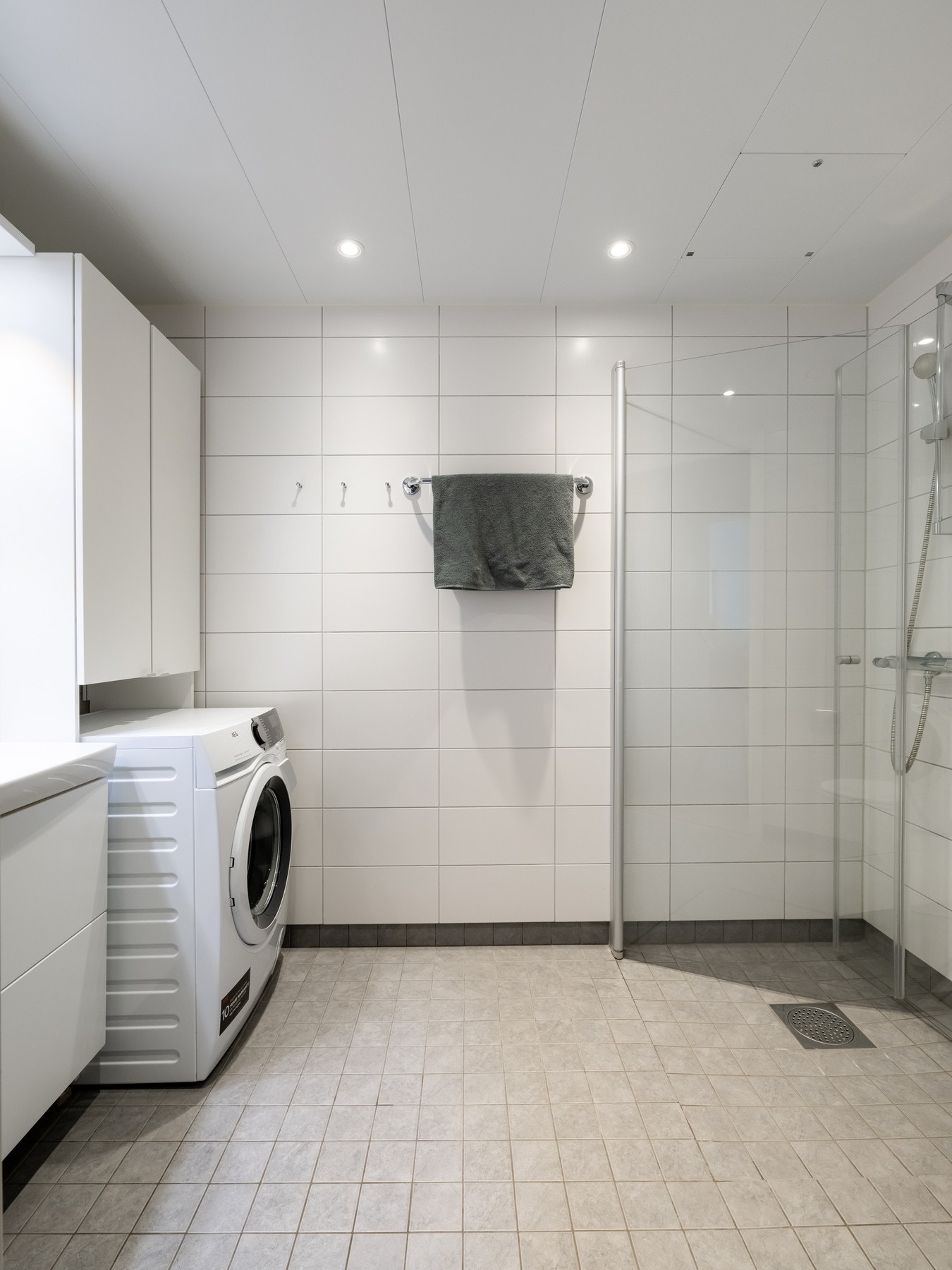 Lyst, flislagt baderom med varme i gulv og downlights i himling. Galleribilde