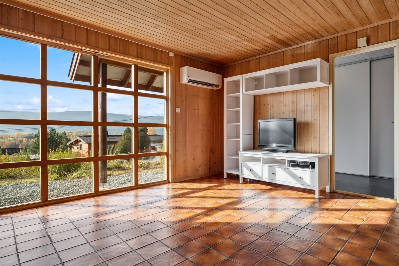 Videre kommer du inn i en lys og hyggelig stue med flislagt gulv og gulvvarme. Galleribilde