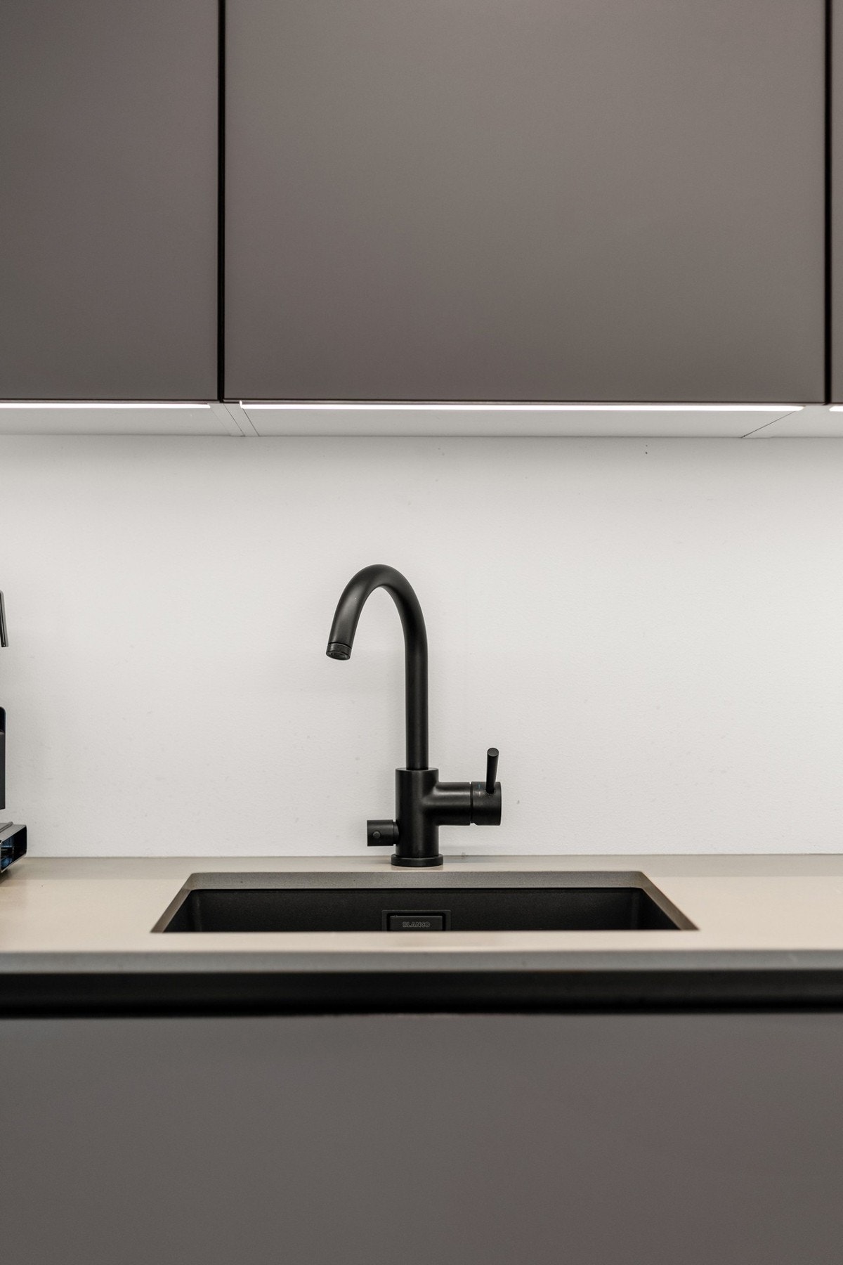 Stilrent kjøkken fra HTH m/integrerte hvitevarer og benkeplate i kompositt. Galleribilde