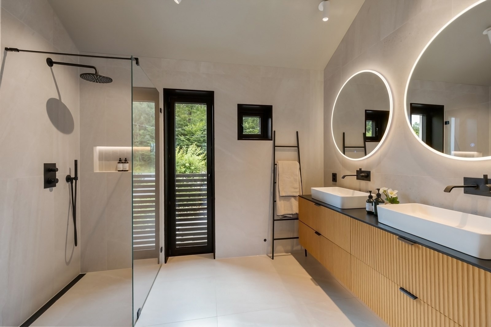 Stilfult og moderne bad med dobbel servant og speil med integrert belysning. Galleribilde