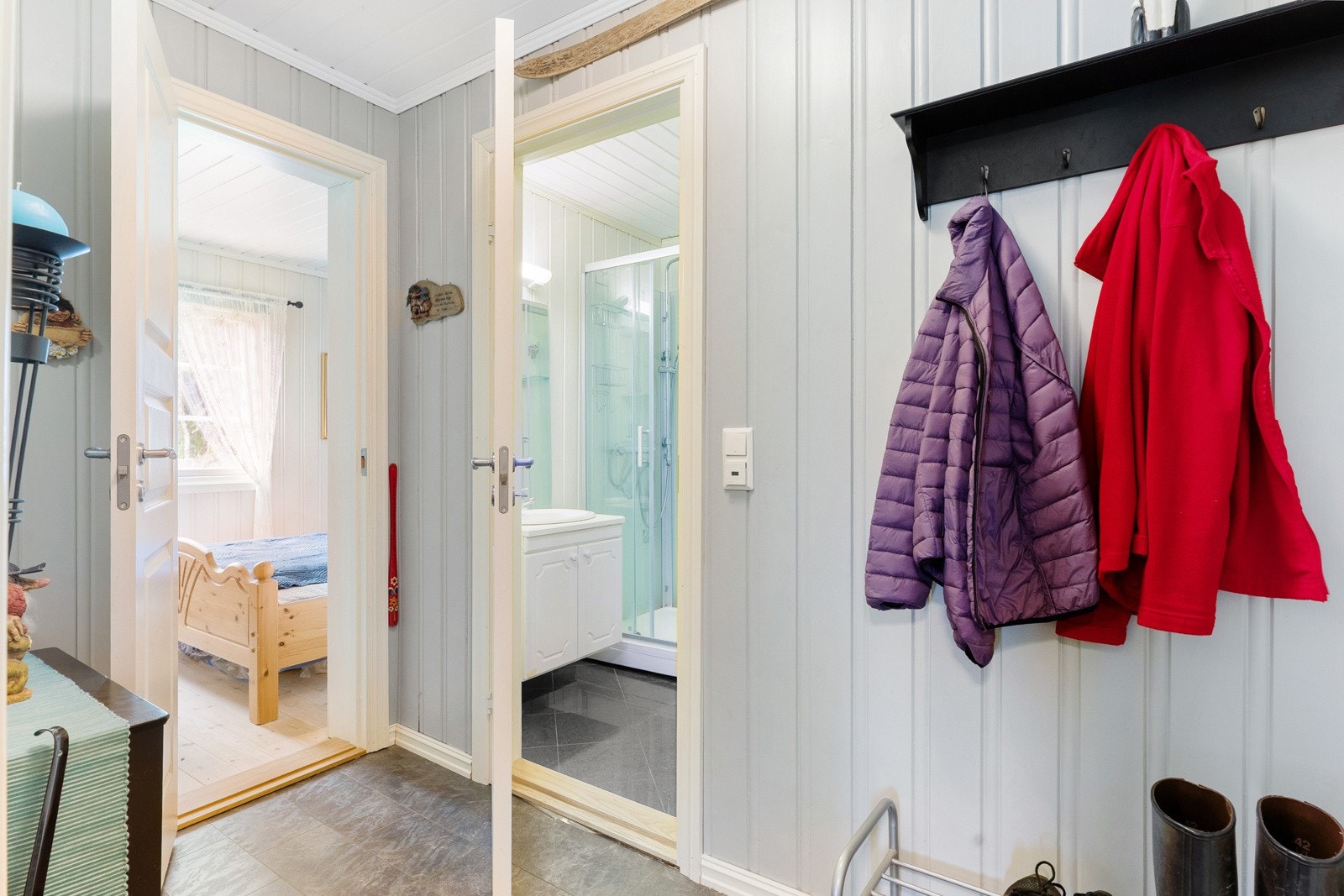 Entre med lysmalt trepanel på vegger og belegg på gulv med gulvvarme. Galleribilde