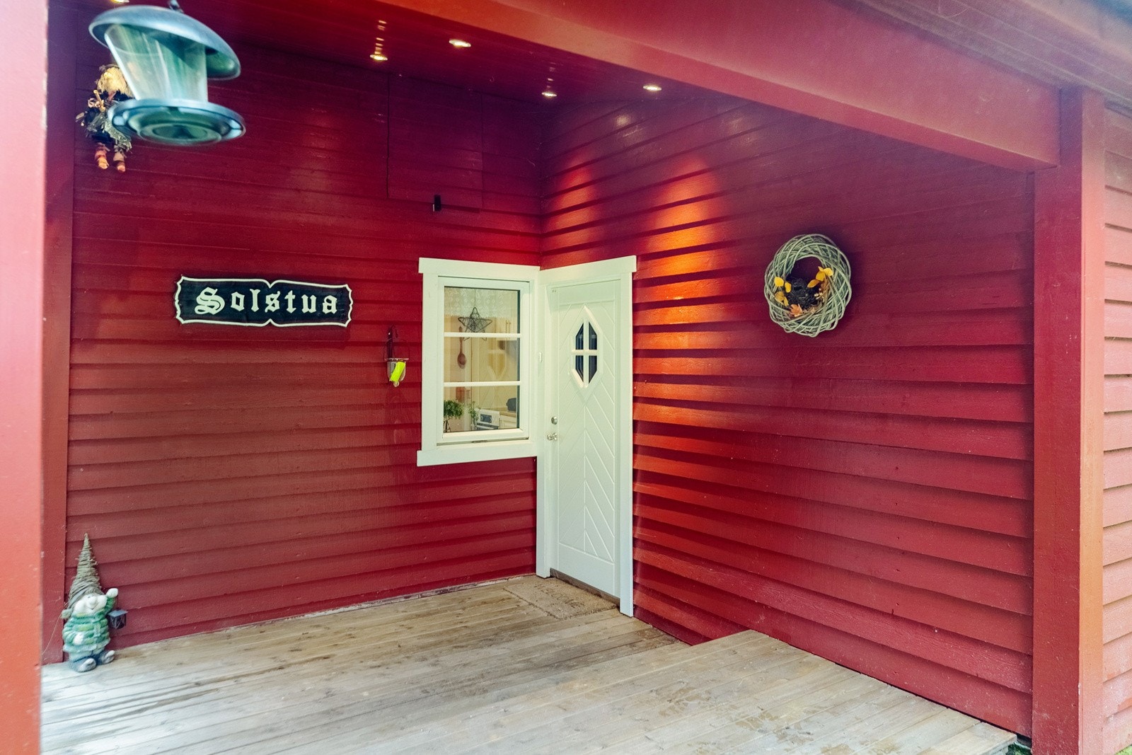 Utgang fra entré til nordvendt terrasse på 10 kvm. Terrassen har utebelysning og takoverbygg. Galleribilde