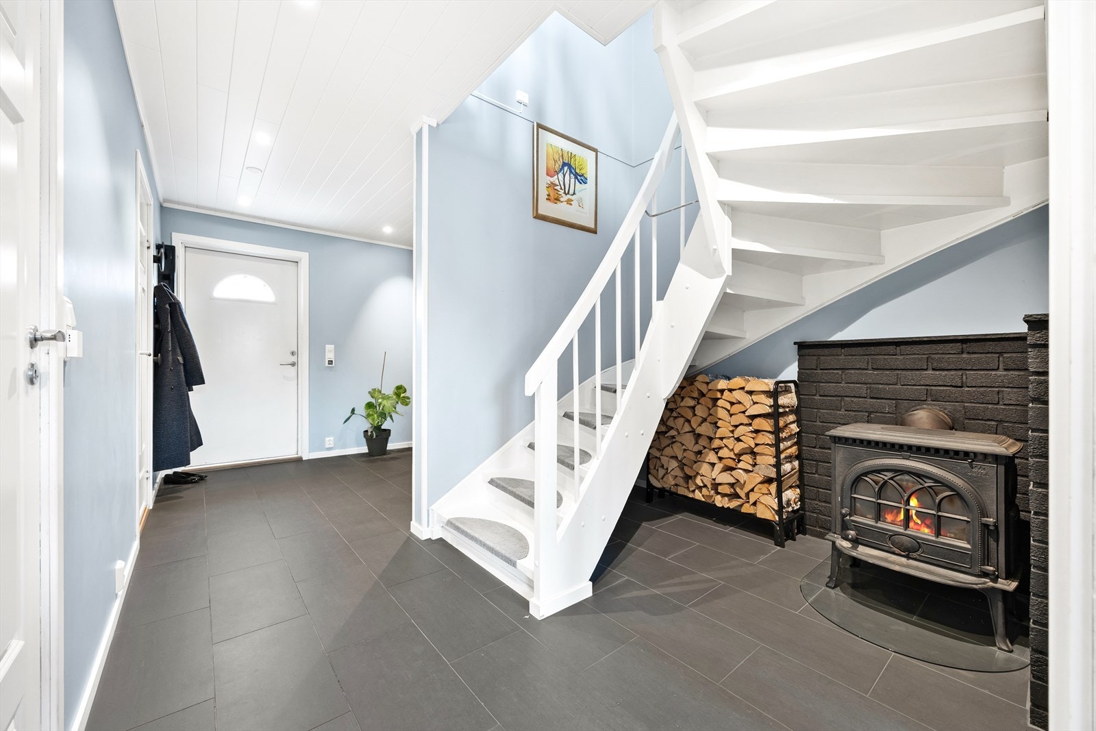 En lukket vedovn er plassert under trappen og gir god varme. Galleribilde