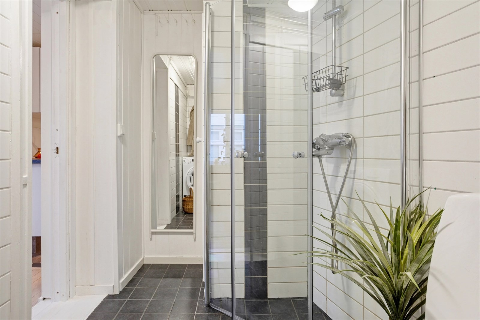 Lyst og pent bad på 4,5 m² med keramiske fliser på gulv og vegger, en vegg med malt panel og behagelig gulvvarme som gir ekstra komfort. Galleribilde