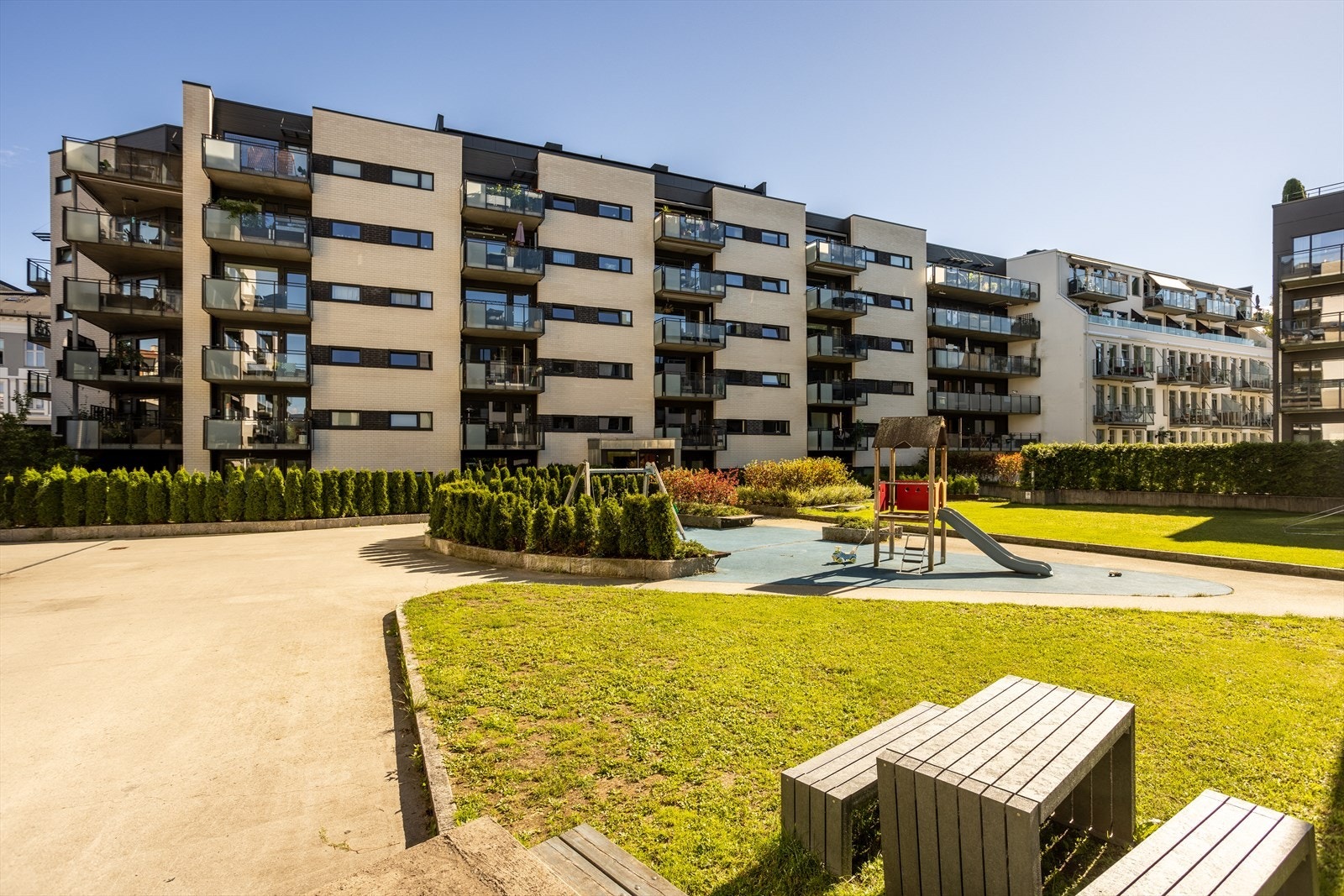 Fin lekeplass i bakgården for barna i nabolaget med flotte sittegrupper rundt Galleribilde