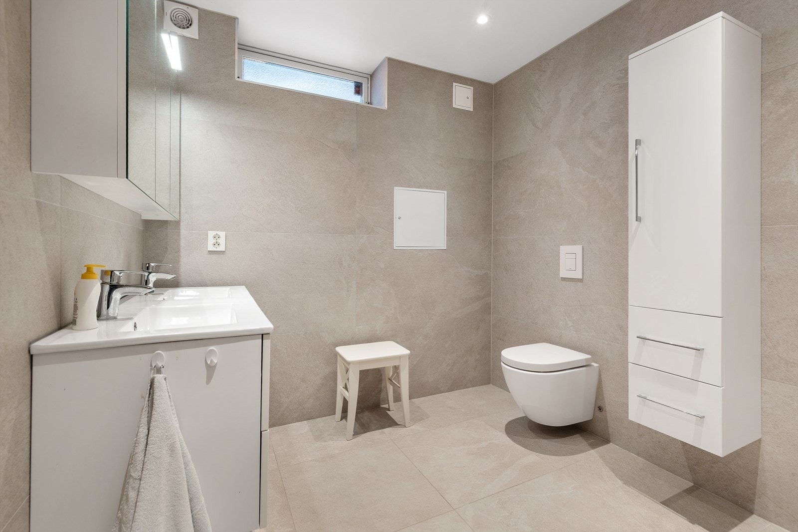 Innredningen består av servant, veggmontert toalett og dusjsone. Galleribilde