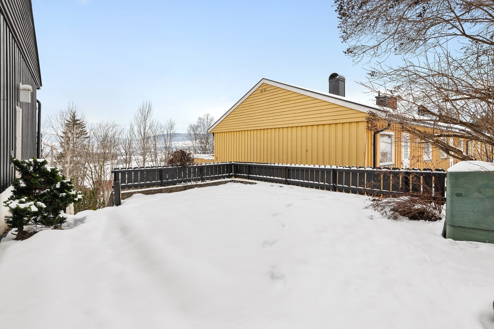 Tomten er pent opparbeidet med plenarealer og beplantning. Galleribilde