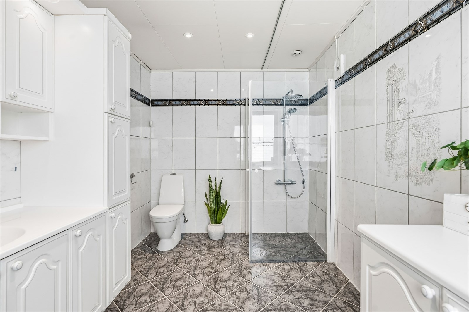 Innredningen består av Skap med profilerte fronter, samt servant, gulvstående klosett og dusj på gulv. Badet har elektrisk avtrekk på yttervegg. Galleribilde