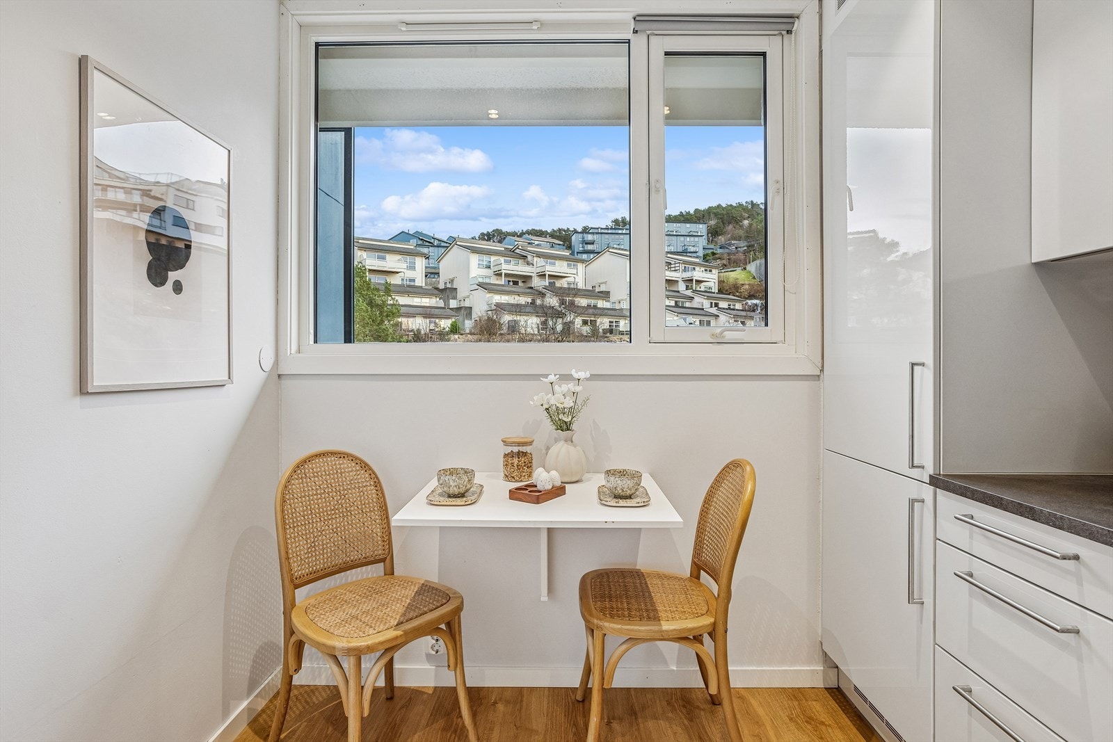 Et smart, vegghengt klaffebord ved vinduet gir en praktisk spiseplass. Galleribilde