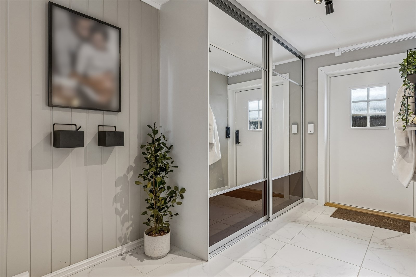 Inngangspartiet har god plass til oppbevaring med en stor skyvedørsgarderobe med speilfronter. Galleribilde