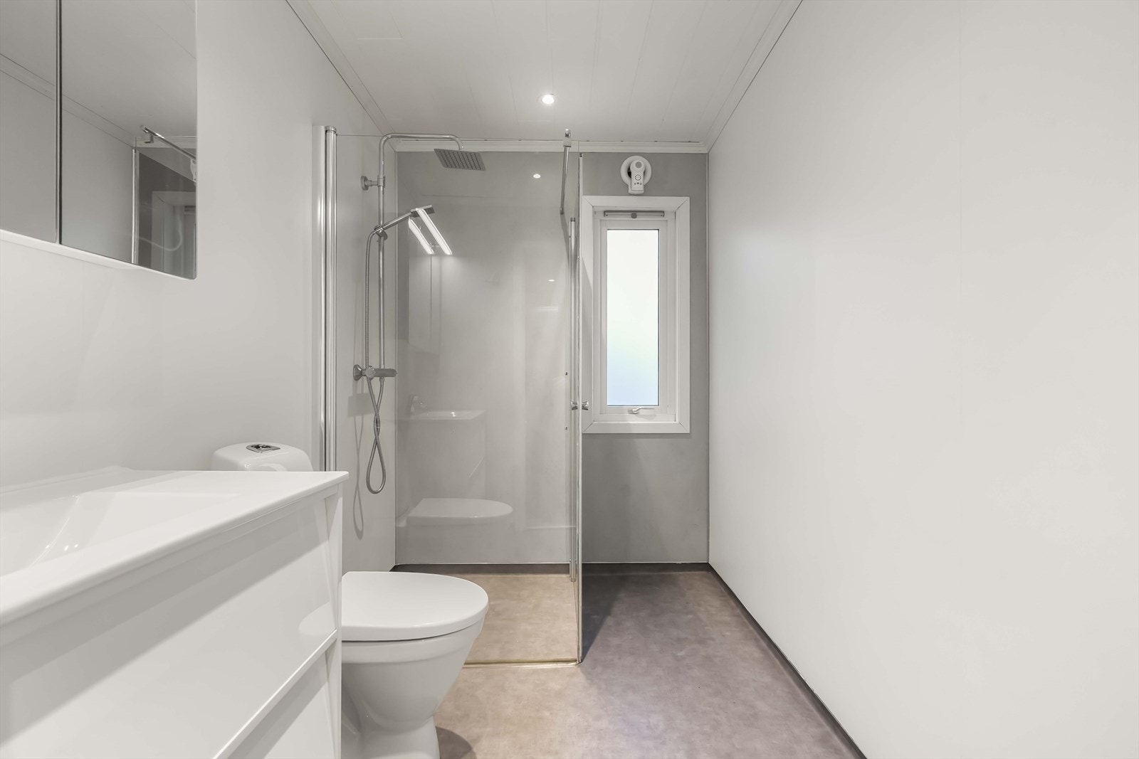 Stilreint bad på hovudplan med varmekablar i golv og downlights i himling Galleribilde