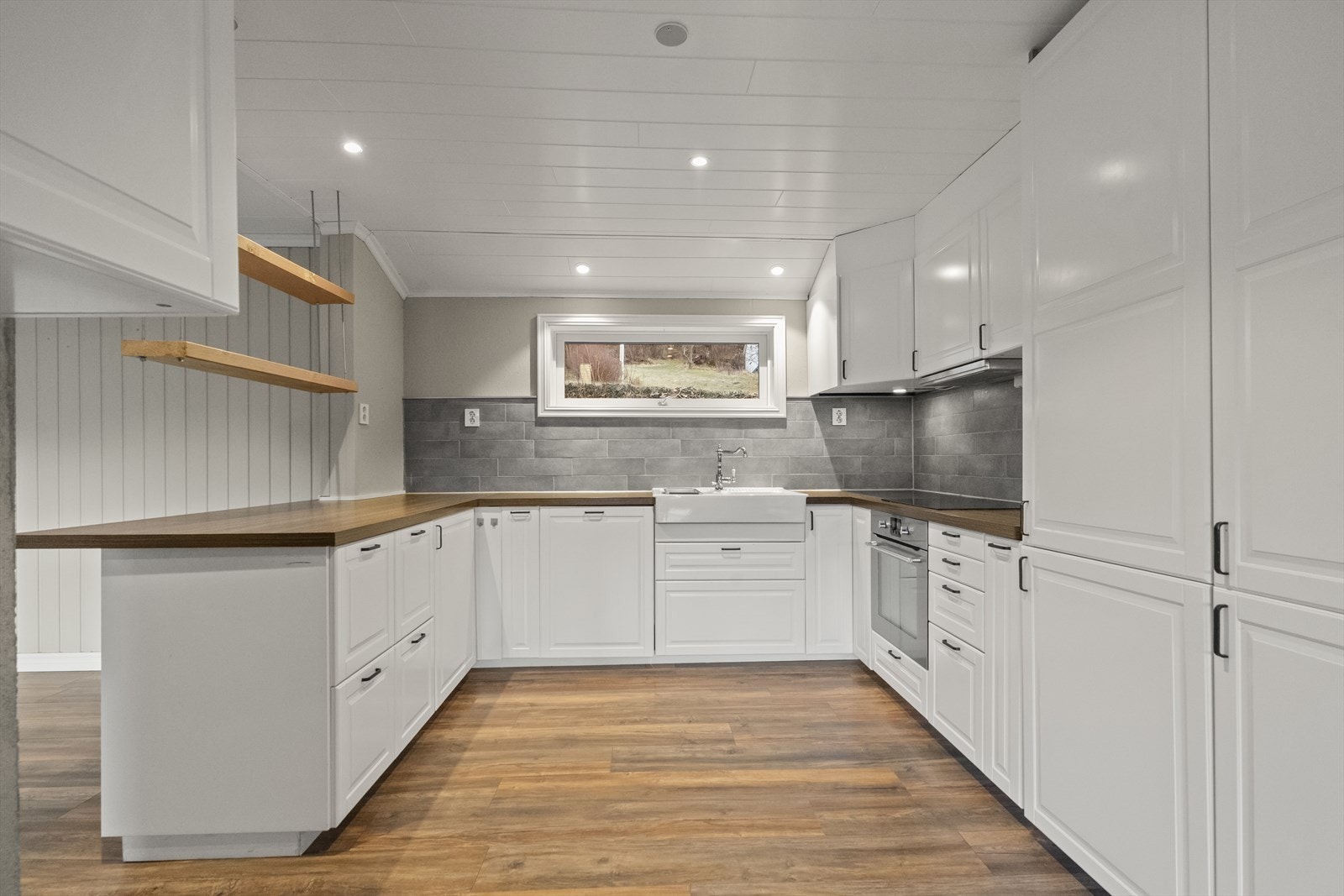 Tidlaus kjøkkeninnredning med mykje skap- og benkeplass Galleribilde