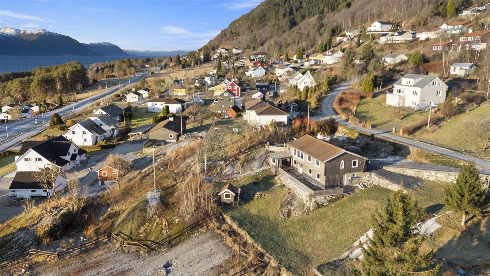 Mot sør er det opparbeida hage med plen og leikehytte Galleribilde