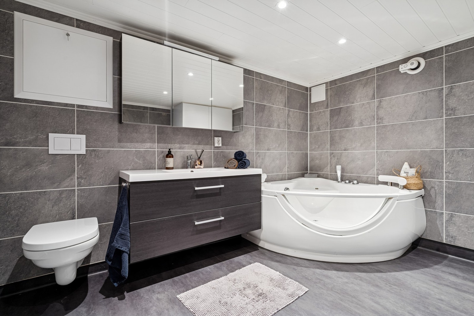 Badet i kjeller ble oppgradert i 2021 og holder en moderne standard med gulvvarme, baderomsplater på vegger, vegghengt toalett, badekar med innebygd armatur, vaskeromsinnredning og opplegg for vaskemaskin. Galleribilde