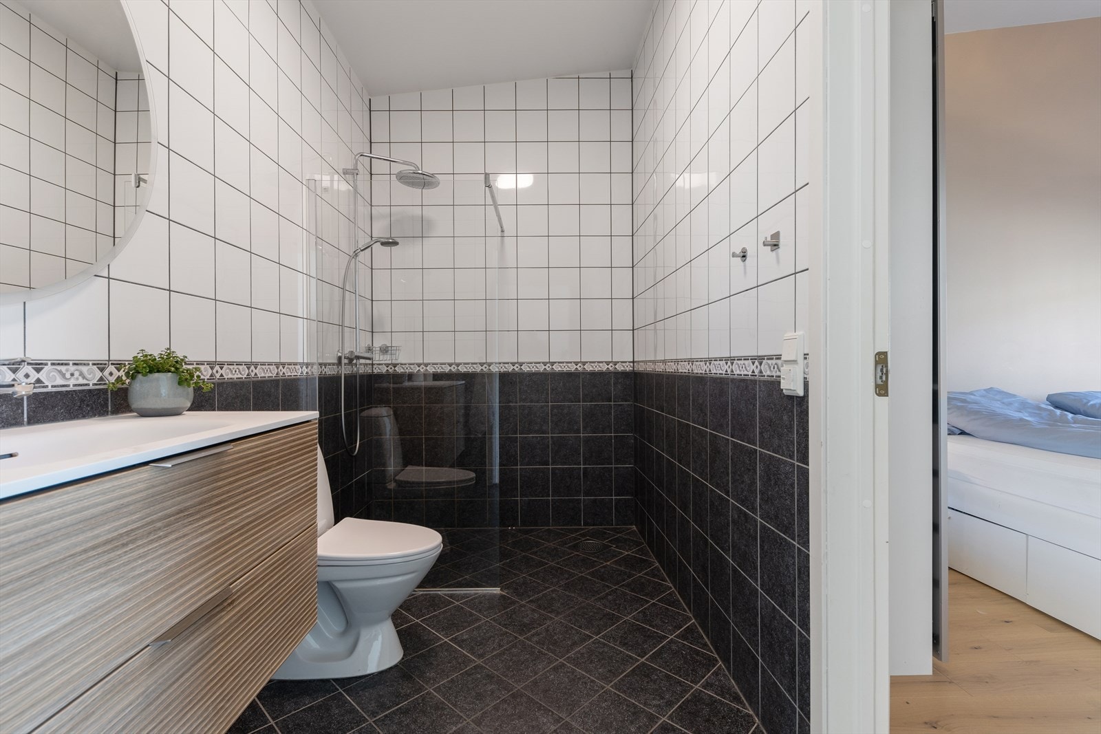 Badet er ellers utstyrt med dusjhjørne, toalett og baderomsinnredning med nedfelt servant. Galleribilde