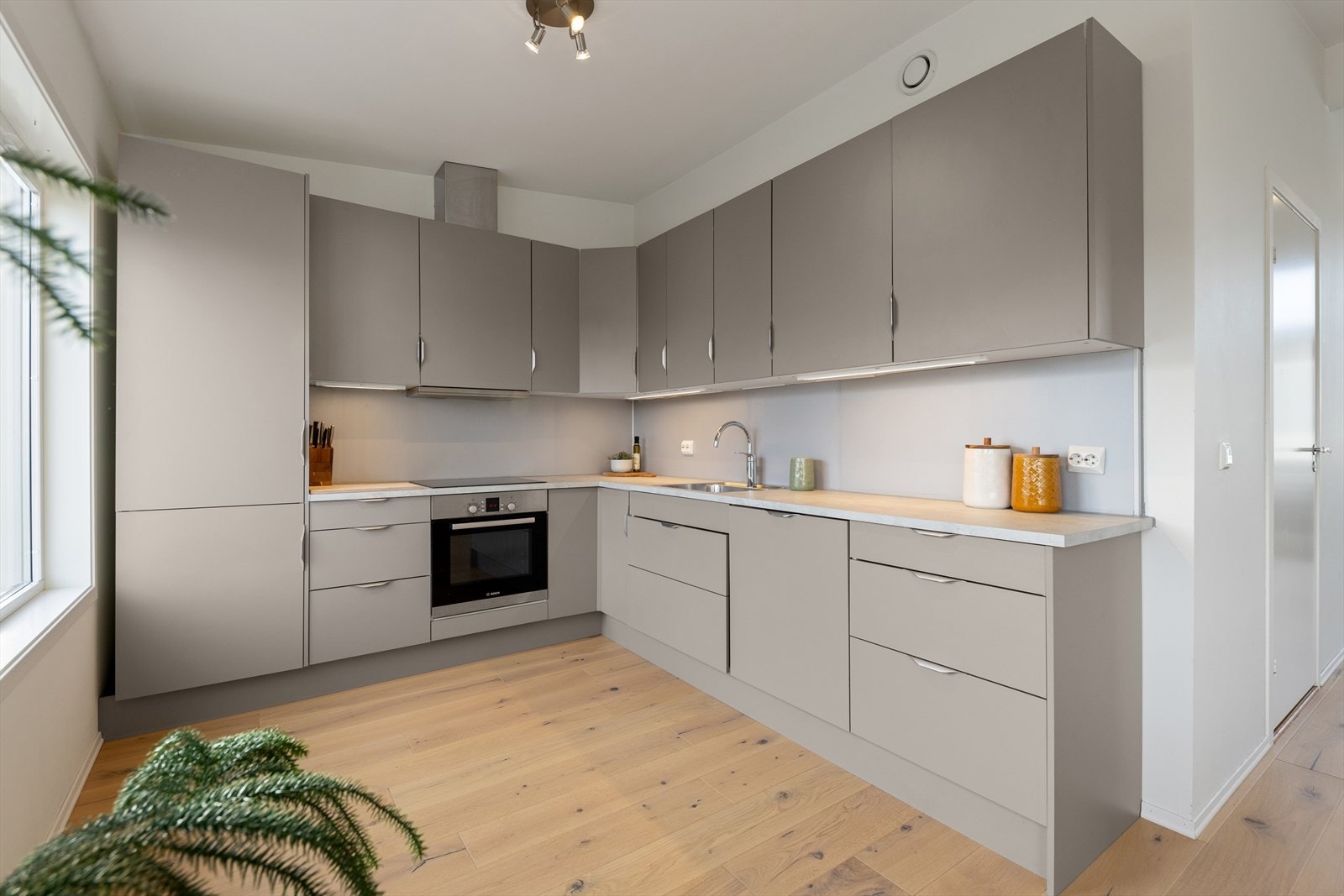 Kjøkkenet ble byttet i 2024 og er stilrent og lekkert innredet med beige, slette fronter og lys benkeplate i laminat. Et romslig kjøkken som gir godt med skap- og skuffeplass, samt gode arbeidsflater på benk. Galleribilde