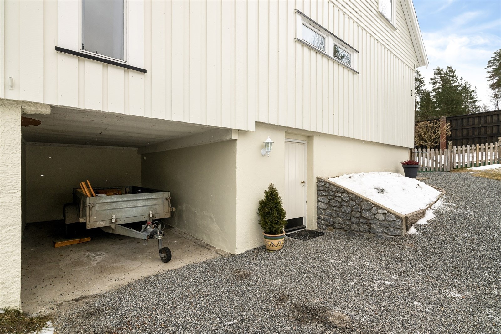 Innlemmet i kjelleretasjen er det carport, hvor det i 2025 ble installert ladeboks til el-bil, utført av Foss Elektro. Galleribilde